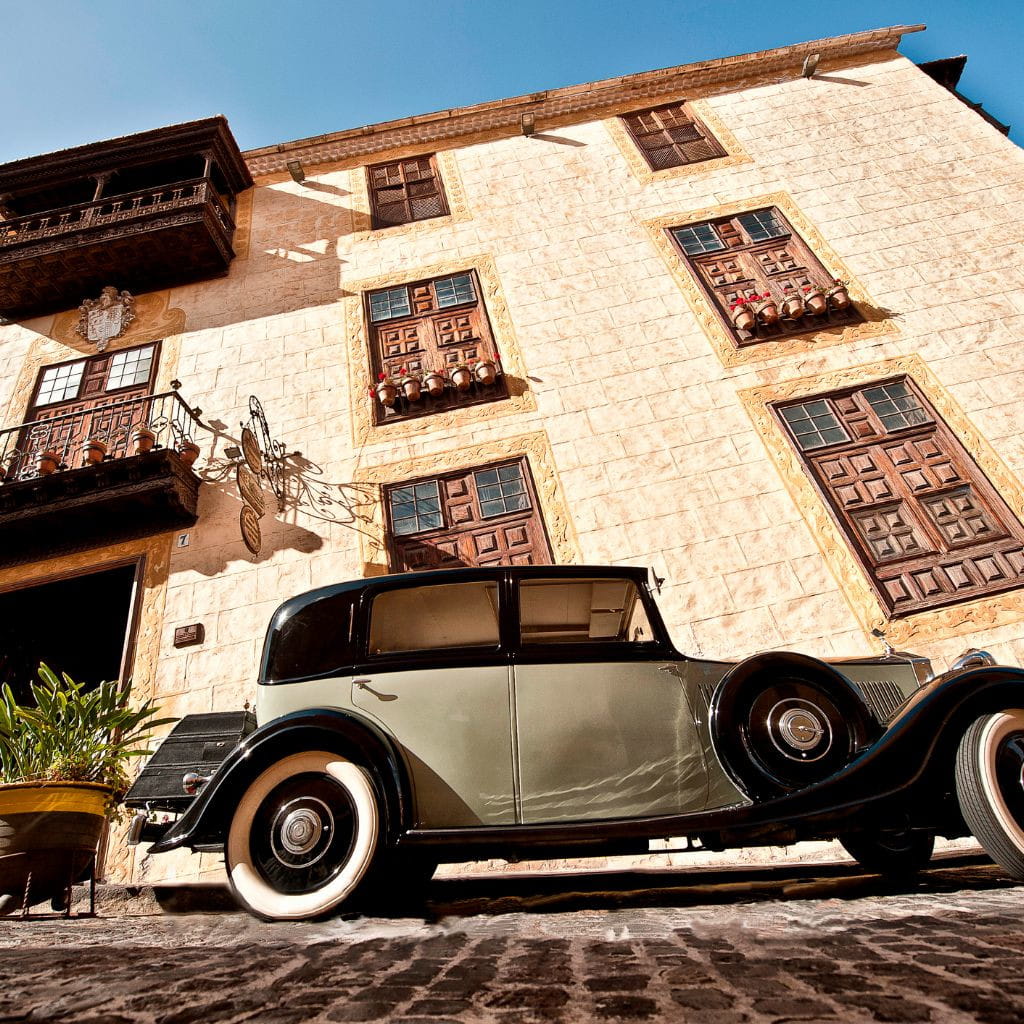 Klassieke auto geparkeerd voor een historisch gebouw op Tenerife.