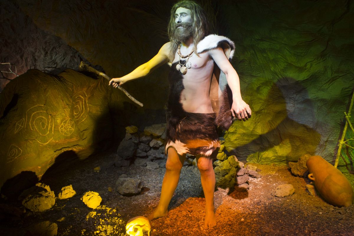 Prehistorische man in bontkleding in een grot, Tenerife.