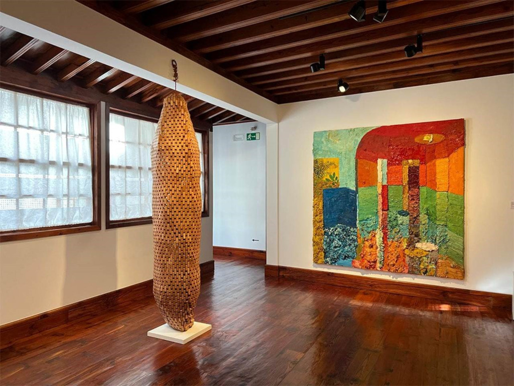 Houten beeldhouwwerk en abstracte schilderkunst in een kunstzaal op Tenerife.