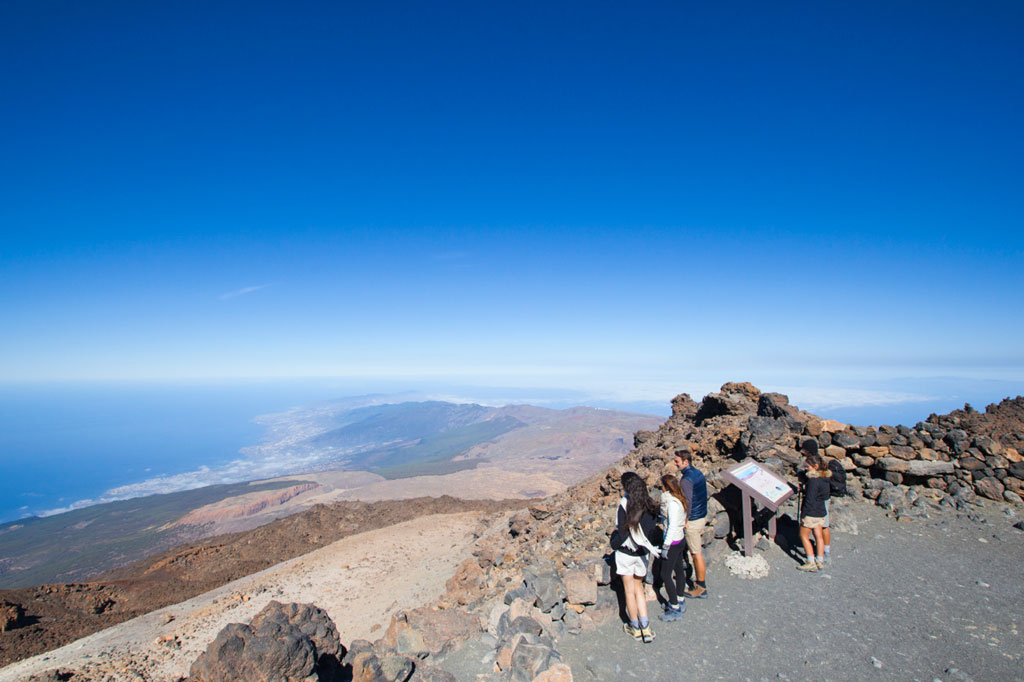 Mensen die een informatieposter lezen in het landschap van de berg Teide, Tenerife.