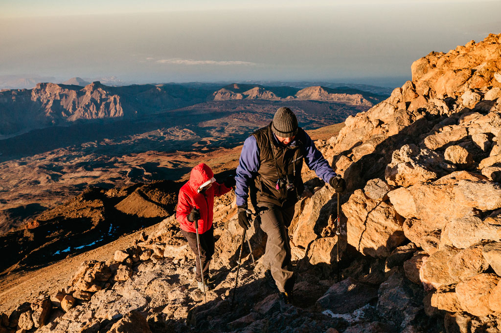 Mensen die op de berg Teide op Tenerife klimmen, met een bergachtig landschap op de achtergrond.