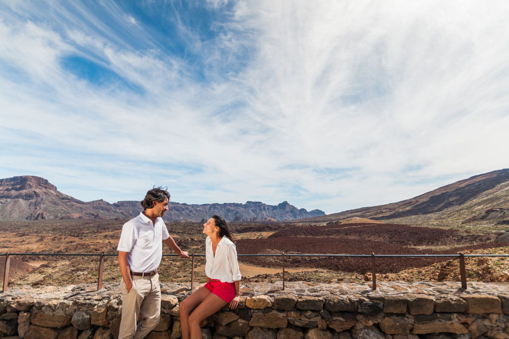 Een paar dat op de achtergrond met het landschap van de berg Teide praat.