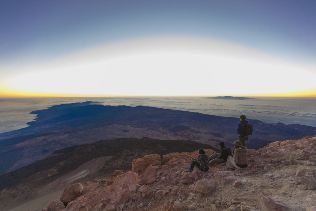 Mensen kijken naar de zonsopgang vanaf de top van de berg Teide op Tenerife.