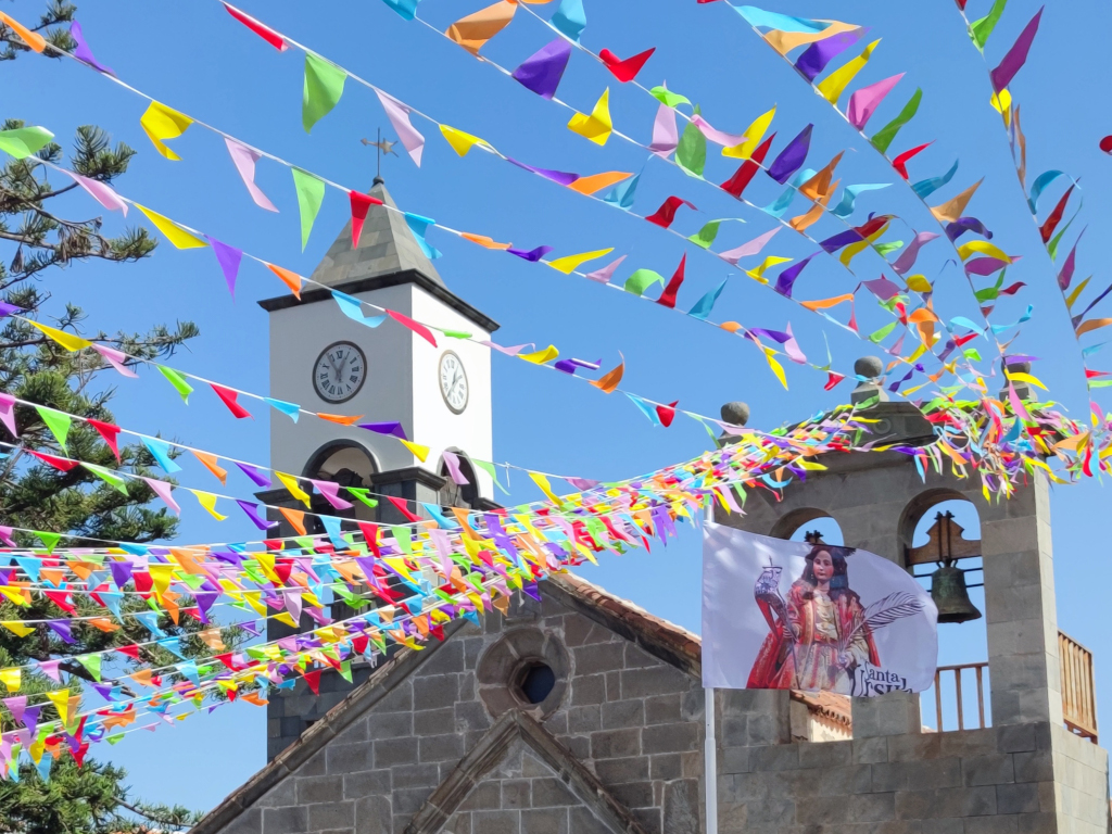Kerktoren op Tenerife met kleurrijke wimpels en de vlag van Santa Úrsula.