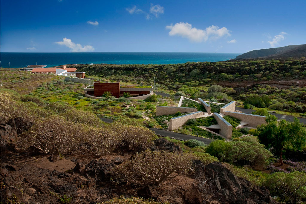 Bezoekerscentrum in Punta de Teno, Tenerife, omringd door groen en zee op de achtergrond.