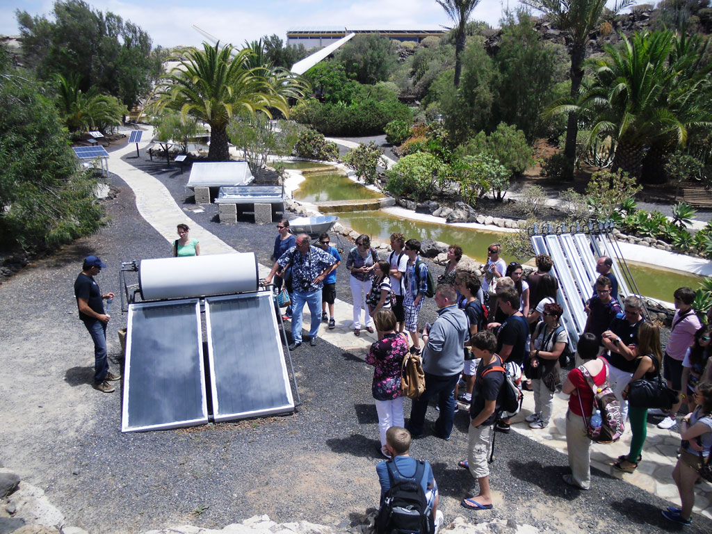 Groep mensen die zonnepanelen observeert in een park op Tenerife.