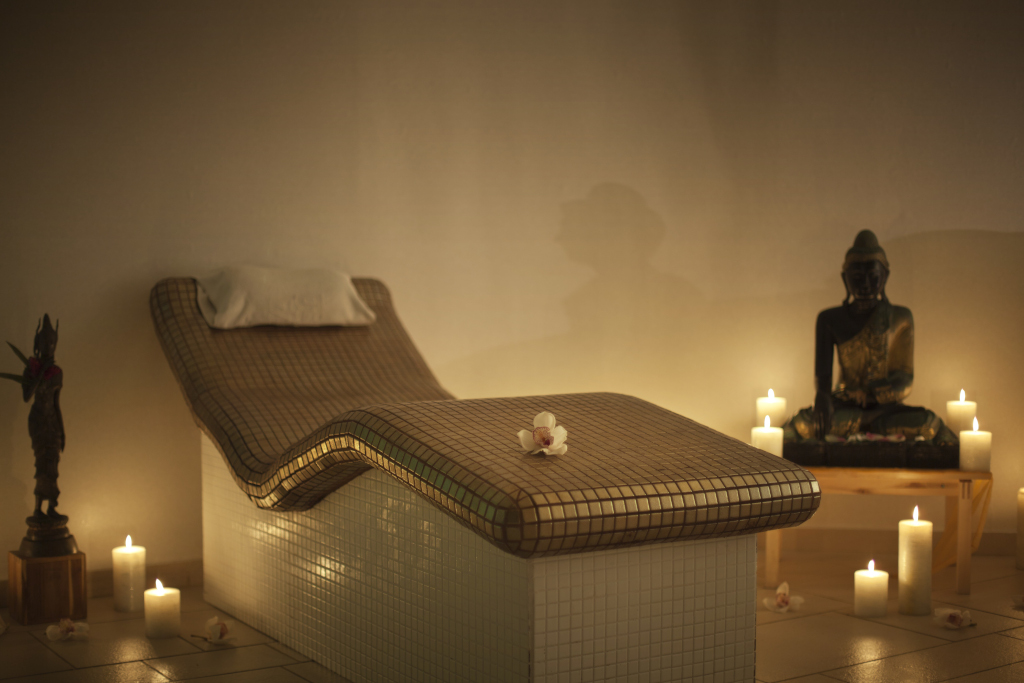 Massagetafel met kaarsen en standbeeld in een spa op Tenerife.